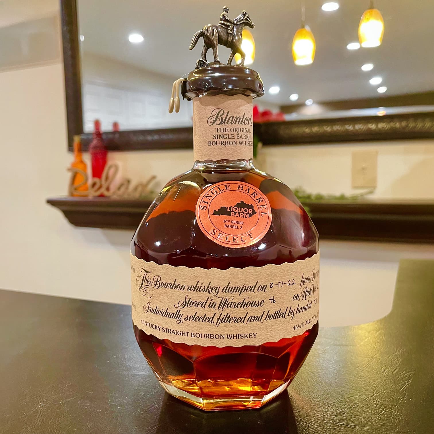 A bottle of Blanton's Single Barrel Bourbon Whiskey sits on a countertop.